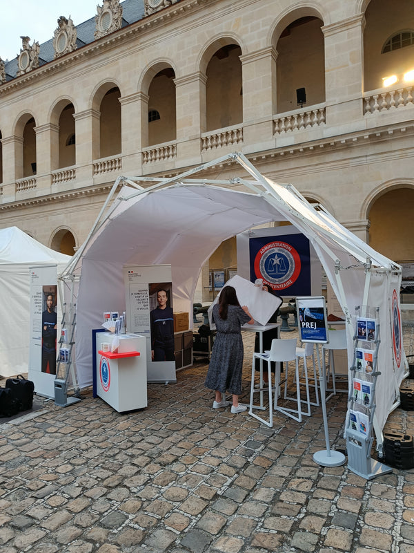 Konligo AK470 foldable event structure with inner white membrane used as an outdoor information booth at a historic venue, featuring promotional displays and seating, now available on MTN SHOP US.
