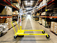 An OZ Lifting Products XR 500 Davit Crane with a white mast and boom, mounted on a yellow portable mobile wheel base inside a warehouse aisle. - imagen 4